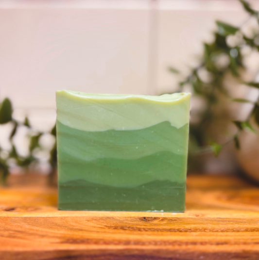 Green soap bar on a wooden surface with a blurred background